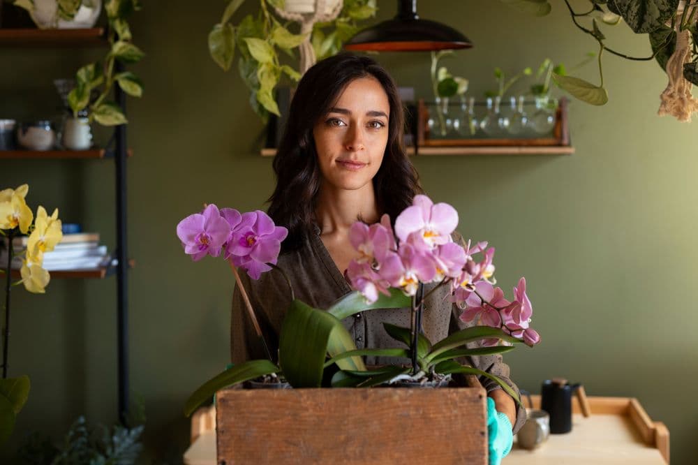 Woman decorating her house with orchids